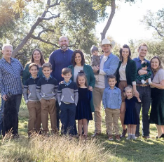 Large family smiling in a grassy field