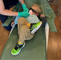 Young boy having his teeth cleaned in the dental chair