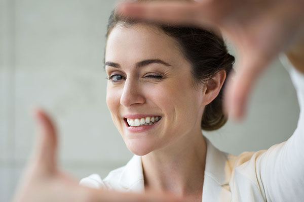 woman holding up her hands as if taking a picture