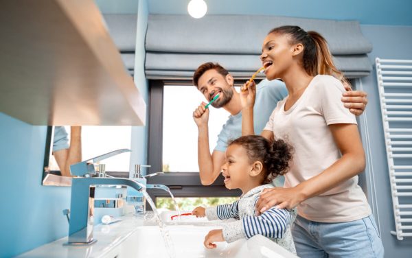 family of three brushing their teeth