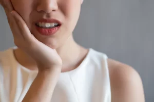 woman with misaligned smile experiencing dental pain