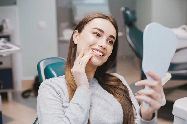 young woman smiling at her reflection