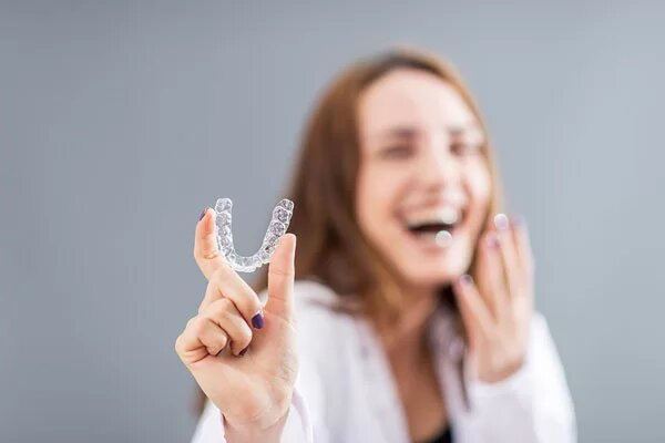 lady holding a SureSmile aligner